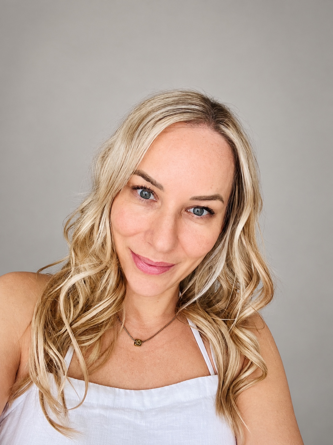 Sandra in a white dress, with blonde curls and a gentle smile